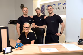 3 Physiotherapeuten und Ihre Anmeldekraft stehen hinter dem Anmeldetresen